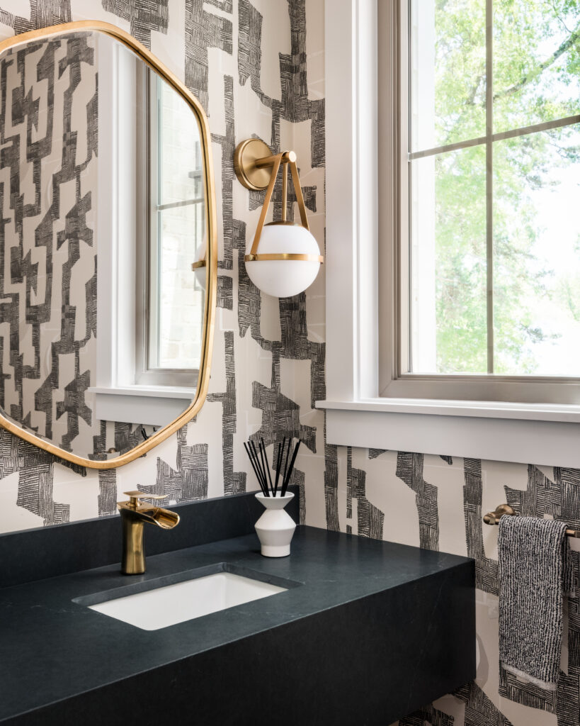 Custom powder room with statement wallpaper, modern vanity, and designer lighting in a luxury new build