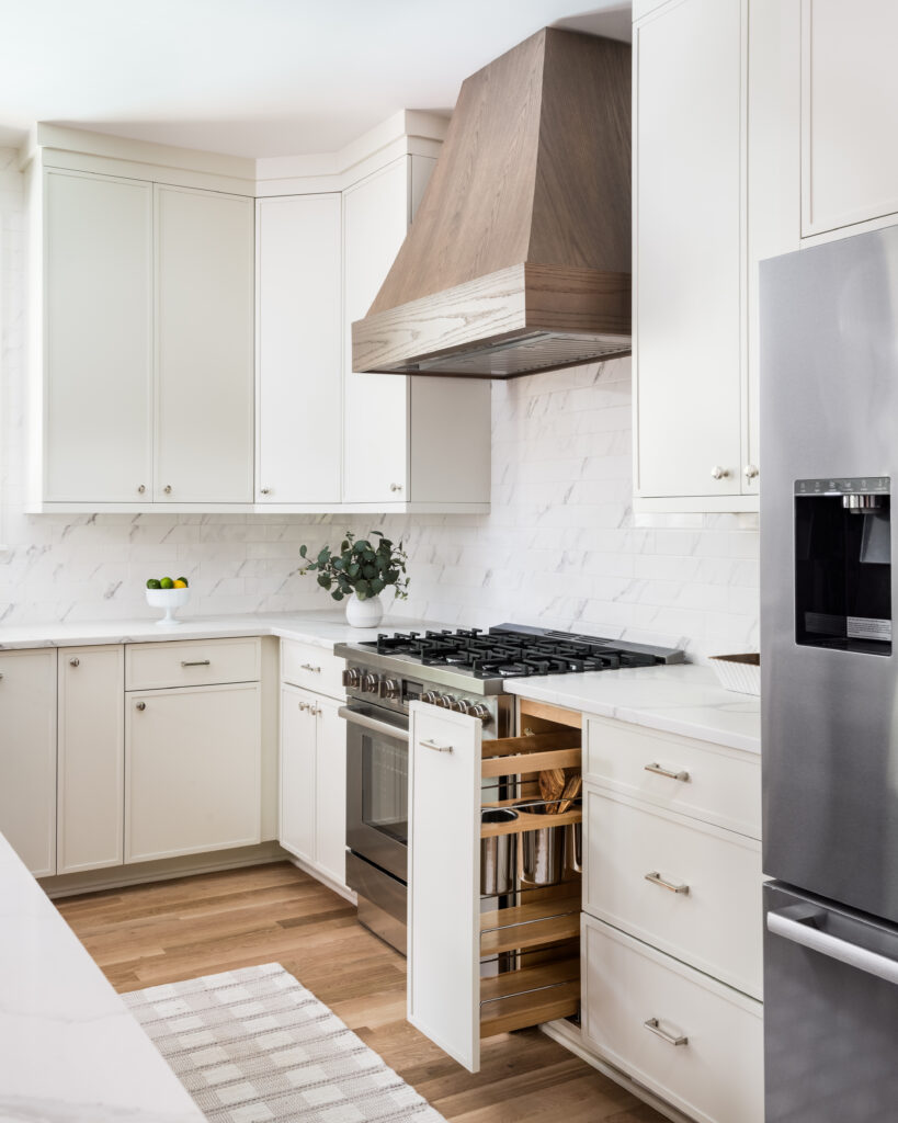Custom kitchen with white cabinetry, marble backsplash, and built-in storage solutions in a newly built Charlotte home