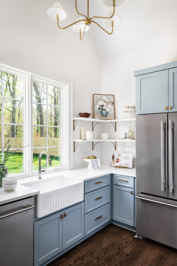 Custom scullery with blue cabinetry, farmhouse sink, open shelving, and natural light.