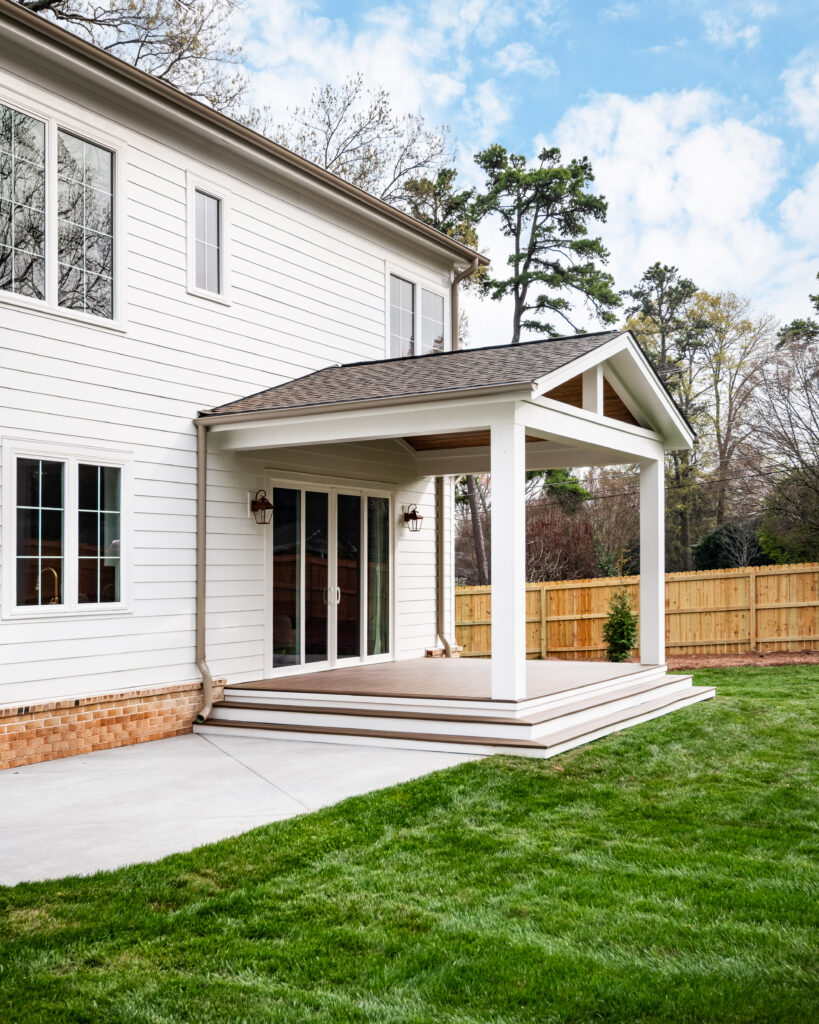 Luxury custom home with covered outdoor living area, stained wood vaulted ceiling, and backyard patio.